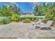 Backyard patio with lounge chairs and lush landscaping, perfect for outdoor relaxation and entertaining at 1281 Gatewood Ave, Minneola, FL 34715