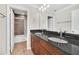 Elegant bathroom with double granite vanity and mirrors, leading to a tiled shower and bathtub at 1281 Gatewood Ave, Minneola, FL 34715