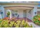 Inviting front porch with stone accents, stylish lighting, and comfortable seating area surrounded by vibrant plants at 1281 Gatewood Ave, Minneola, FL 34715