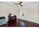 Well-lit home office featuring dark hardwood flooring, a desk, and a view of the neighborhood at 1281 Gatewood Ave, Minneola, FL 34715