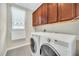Modern laundry room with updated appliances and dark wood cabinetry for storage at 1281 Gatewood Ave, Minneola, FL 34715
