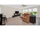 Spacious living room with tiled flooring, a comfortable leather sofa, and large windows offering natural light at 1281 Gatewood Ave, Minneola, FL 34715