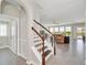 Open staircase leading to the living room, featuring wood and white railings, tile floors and natural light at 1281 Gatewood Ave, Minneola, FL 34715