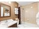 Tiled bathroom features a vanity, toilet, bathtub with shower, and decorative coastal-themed accents at 13050 Se 120Th St, Ocklawaha, FL 32179