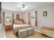 Neutral bedroom offers two windows, hardwood floors, and a decorative dresser with a lamp at 13050 Se 120Th St, Ocklawaha, FL 32179
