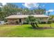 Charming single-story home featuring a metal roof, lush lawn, and mature landscaping at 13050 Se 120Th St, Ocklawaha, FL 32179