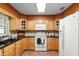 Traditional kitchen features tile floors, stone backsplash, light wood cabinetry, and a white oven range at 13050 Se 120Th St, Ocklawaha, FL 32179