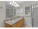 Bright bathroom featuring a double vanity with granite countertop and a tiled walk-in shower at 1358 E Schwartz Blvd, The Villages, FL 32159