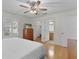 Bedroom featuring hardwood floors, ceiling fan, and views to an ensuite and walk-in closet at 1358 E Schwartz Blvd, The Villages, FL 32159