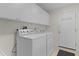 Bright laundry room with washer, dryer, sink, and white cabinets for ample storage at 1358 E Schwartz Blvd, The Villages, FL 32159