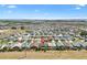 Expansive aerial view of a dense residential area with varied rooftops, showcasing a community layout at 1409 Gatlin Pl, The Villages, FL 32163