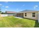 A well-maintained backyard features a lawn and screened patio, complemented by views of neighboring properties at 1409 Gatlin Pl, The Villages, FL 32163
