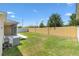 An expansive, well-maintained backyard with a lush lawn, bordered by a fence and featuring the screened patio of the home at 1409 Gatlin Pl, The Villages, FL 32163