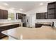 Modern kitchen with stainless steel appliances, dark cabinetry and stone countertops at 1409 Gatlin Pl, The Villages, FL 32163