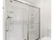 Clean white shower featuring glass doors and built in shelving at 1409 Gatlin Pl, The Villages, FL 32163
