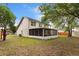 The backyard features a screened-in porch and mature trees at 1413 Silverthorn Dr, Orlando, FL 32825