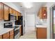 Kitchen area featuring wood cabinets, stainless steel appliances, and a view into a carpeted room at 1413 Silverthorn Dr, Orlando, FL 32825
