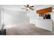 Open living room featuring plush carpeting, ceiling fan, and kitchen bar area at 1413 Silverthorn Dr, Orlando, FL 32825