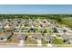 An aerial view of a home in a neighborhood with well-maintained lawns and many other houses at 15287 Aquarius Way, Mascotte, FL 34753