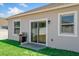 A sliding glass door and windows allow light into the backyard featuring a grill on the grass at 15287 Aquarius Way, Mascotte, FL 34753
