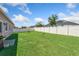 Large grassy backyard enclosed by a white vinyl fence at 15287 Aquarius Way, Mascotte, FL 34753