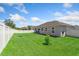 A spacious backyard enclosed by a white fence featuring a healthy green lawn at 15287 Aquarius Way, Mascotte, FL 34753