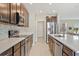 Kitchen with granite countertops and stainless steel appliances, with access to the dining room at 15287 Aquarius Way, Mascotte, FL 34753