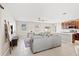 Cozy living room with a sectional couch and a view of the kitchen at 15287 Aquarius Way, Mascotte, FL 34753