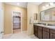Main bathroom boasts double sink vanity, ample lighting, linen closet, and walk-in closet access at 15287 Aquarius Way, Mascotte, FL 34753