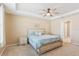 Inviting main bedroom features tray ceiling, neutral color palette, ceiling fan, and ensuite access at 15287 Aquarius Way, Mascotte, FL 34753