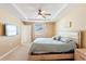 Inviting main bedroom features tray ceiling, neutral color palette, ceiling fan, and ensuite access at 15287 Aquarius Way, Mascotte, FL 34753