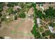 Expansive aerial view showcases a charming home on a large lot with mature trees, outlined in green at 155 W C-466, Lot # 1 W C 466, Oxford, FL 34484
