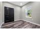 This bedroom features wood-look floors, a double door closet, and a window at 155 W C-466, Lot # 1 W C 466, Oxford, FL 34484