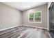 Bedroom with wood-look flooring and a large window offering a view of the backyard at 155 W C-466, Lot # 1 W C 466, Oxford, FL 34484