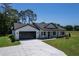 Picture of a charming home featuring an attached garage, a covered entry and manicured landscaping at 155 W C-466, Lot # 1 W C 466, Oxford, FL 34484