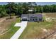 Aerial view of a charming home featuring a long drive, an attached garage, and lush greenery surrounding the property at 155 W C-466, Lot # 1 W C 466, Oxford, FL 34484