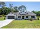 Charming single-story home with a well-manicured lawn, black accents, and an attached two-car garage at 155 W C-466, Lot # 1 W C 466, Oxford, FL 34484