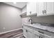 This laundry room features granite countertops and white cabinets at 155 W C-466, Lot # 1 W C 466, Oxford, FL 34484