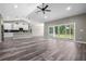 Open-concept living room with sleek floors, vaulted ceiling, and sliding glass doors to the outdoor space at 155 W C-466, Lot # 1 W C 466, Oxford, FL 34484