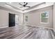 Bright main bedroom with tray ceiling, ceiling fan, barn door entrance to bathroom, and wood-look flooring at 155 W C-466, Lot # 1 W C 466, Oxford, FL 34484