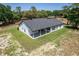 Aerial view of the home's rear, featuring a covered patio and a picturesque view of the backyard and green surroundings at 155 W C-466, Lot # 1 W C 466, Oxford, FL 34484