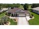 Beautiful home with a three-car garage, manicured lawn, and patterned driveway at 17194 Se 85Th Willowick Cir, The Villages, FL 32162