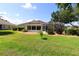Expansive backyard featuring a screened-in porch and ample green space, ideal for outdoor relaxation and entertainment at 17194 Se 85Th Willowick Cir, The Villages, FL 32162