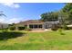 Expansive backyard featuring a screened-in porch and ample green space, ideal for outdoor relaxation and entertainment at 17194 Se 85Th Willowick Cir, The Villages, FL 32162