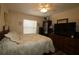 Neutral bedroom featuring a ceiling fan, window, and dresser with large television at 17194 Se 85Th Willowick Cir, The Villages, FL 32162