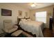 Cozy bedroom features a ceiling fan, a large window, and light patterned bedding at 17194 Se 85Th Willowick Cir, The Villages, FL 32162