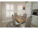 Charming dining nook with wood table, seating for four, and natural light from window with shutters at 17194 Se 85Th Willowick Cir, The Villages, FL 32162