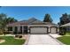 Charming single-story home with a well-manicured lawn and a spacious driveway leading to a two-car garage at 17194 Se 85Th Willowick Cir, The Villages, FL 32162