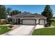 Charming single-story home with a well-manicured lawn and a spacious driveway leading to a two-car garage at 17194 Se 85Th Willowick Cir, The Villages, FL 32162