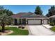 Attractive home with three-car garage, manicured lawn, and patterned driveway at 17194 Se 85Th Willowick Cir, The Villages, FL 32162